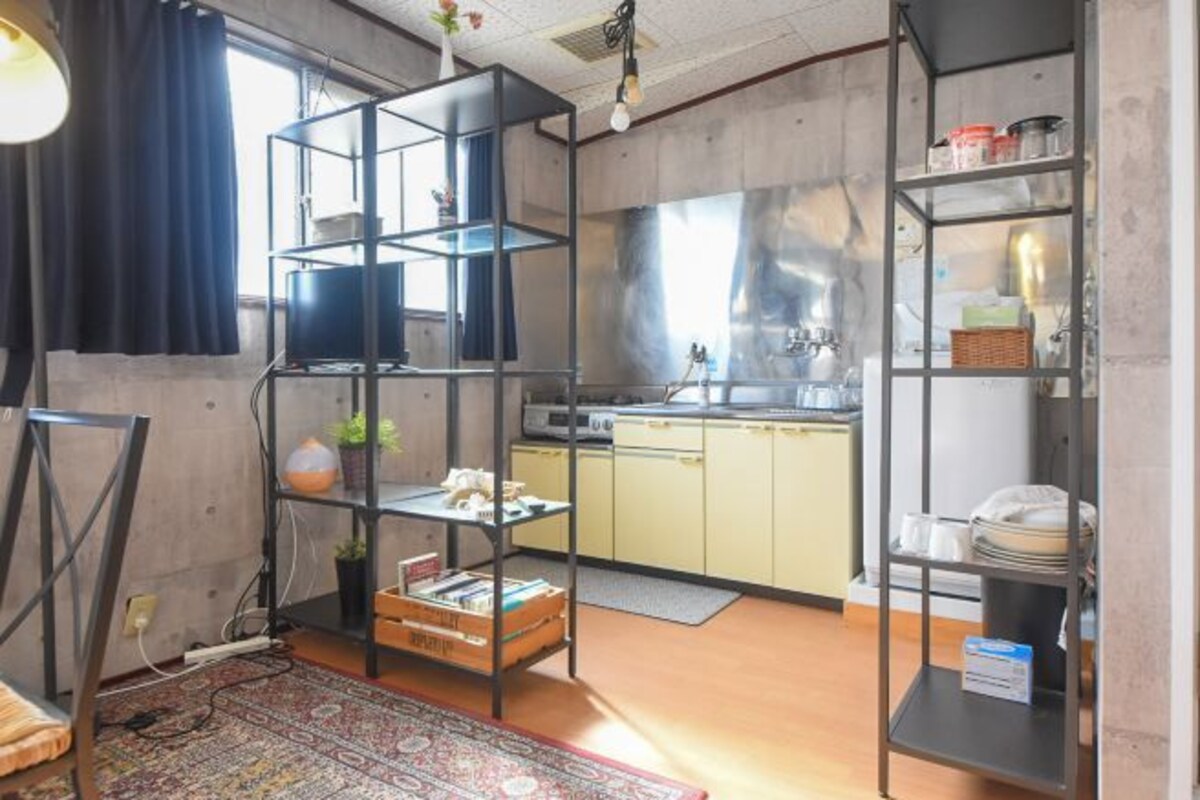 A compact kitchen with a built-in stove, a sink, and a small dining area.
