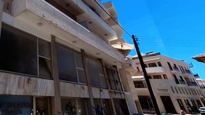 Um edifício com vários andares, grandes janelas e varandas.