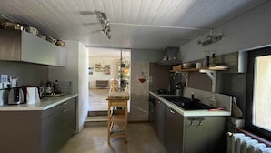 Una cucina moderna con isola centrale, elettrodomestici integrati e vista sull'area soggiorno.