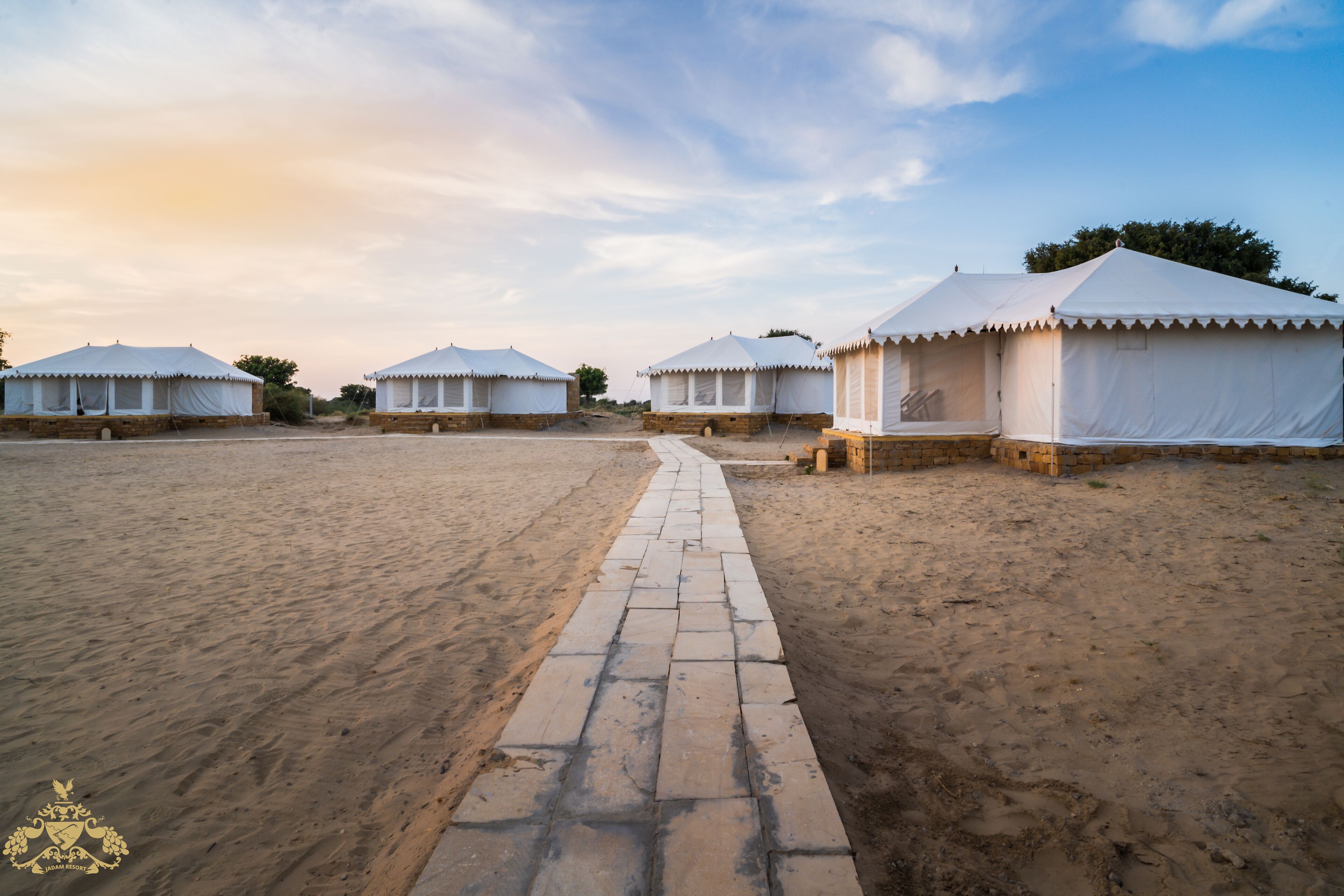 A row of white tents with a paved walkway between them.