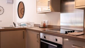 Une cuisine moderne dotée d’appareils électroménagers en acier inoxydable, d’un four encastré et d’un évier muni d’une grille.