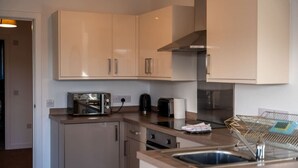 A modern kitchen with stainless steel appliances, wooden cabinets, and a built-in oven.