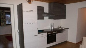 A compact kitchen with white cabinets, a black stove, and a sink. - Apartment Bodensdorf near Gerlitzen Ski Area (Bodensdorf am Ossiachersee)