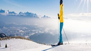 A person skiing on a snowy slope with a mountain range in the background. - Apartment Bodensdorf near Gerlitzen Ski Area (Bodensdorf am Ossiachersee)