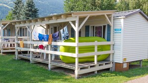 A small, single-story cabin with a porch and a large inflatable pool.
