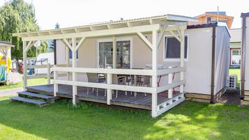 A small, single-story cabin with a covered porch and a sliding glass door.