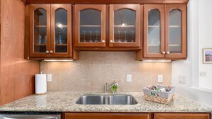 A kitchen with wooden cabinets, a granite countertop, a double sink, and a dish rack. - 2BR Serene Red Rock Retreat - Hot Tub & Nice Views (Sedona)