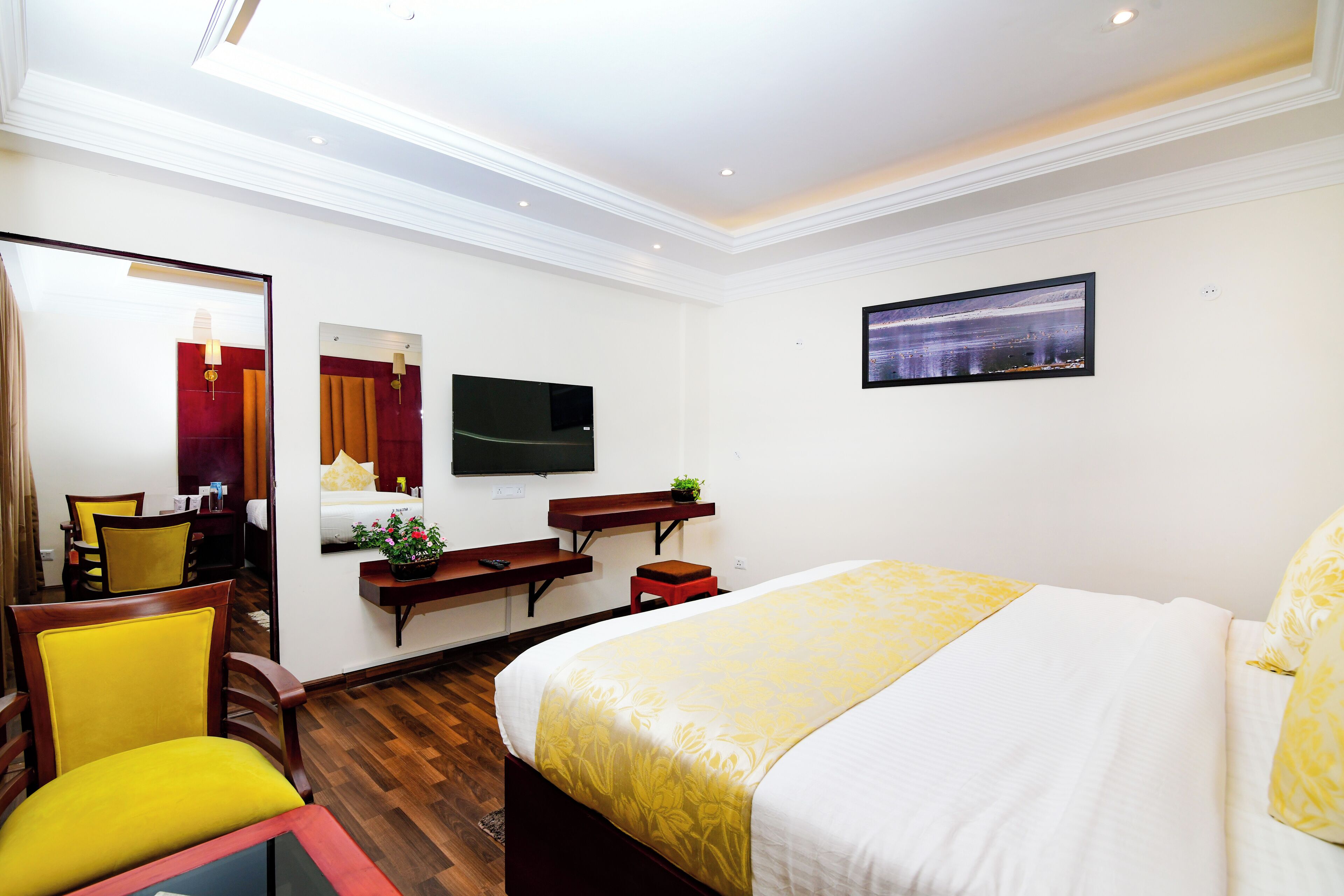 Ein Hotelzimmer mit Bett, Fernseher, Schreibtisch und Stuhl.