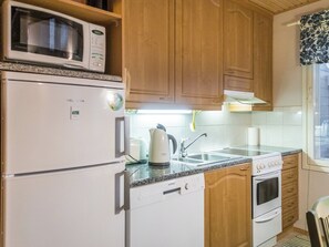 Cocina compacta equipada con microondas, refrigerador, hervidor Bosch, lavavajillas Siemens y estufa.