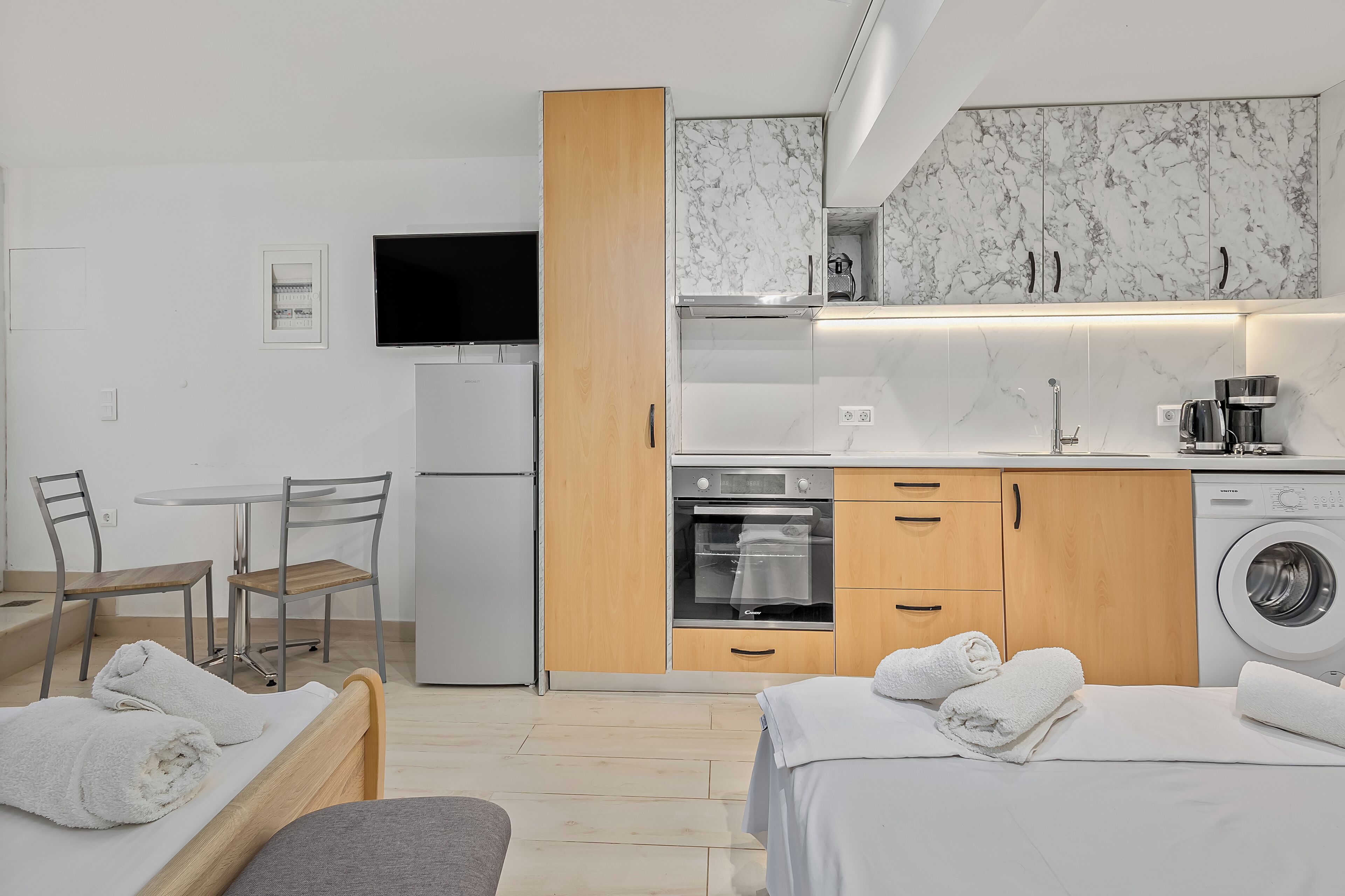 A compact kitchen with a built-in oven, microwave, and coffee maker.
