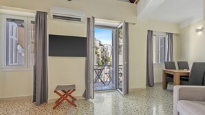 A modern living room with a balcony, a dining area, and an air conditioning unit. - Athens Plaka Family Suites (Athens)