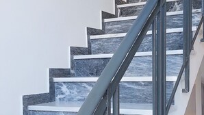A staircase with a metal handrail and marble steps. - Athens Plaka Family Suites (Athens)