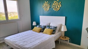Camera da letto con un letto, due abat-jour e decorazioni murali.