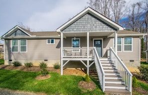 A two-story house with a front porch, a staircase, and a small front yard. - Art-Inspired Retreat | 3BR | Free Tickets (Biltmore Forest)