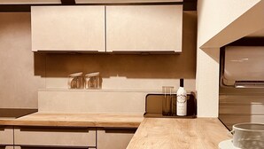 Une cuisine moderne avec des plans de travail en bois, des appareils en acier inoxydable et un design minimaliste.