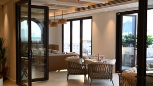 A modern interior with wicker furniture, large windows, and a view of the outdoors. - Mina Hotel and Residences By the Torch (Doha)