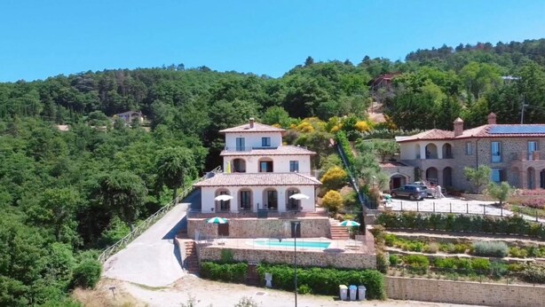 A two-story villa with a pool, surrounded by lush greenery and a hilly landscape. - Villa Maggiorana 10 (Lisciano Niccone)
