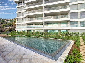 A modern multi-story hotel with a rooftop pool surrounded by greenery. - The Best Sea View Apartment by LovelyStay (Funchal)