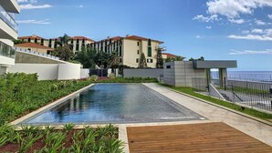 Un hôtel moderne doté d’une piscine sur le toit, d’une végétation luxuriante et offrant une vue sur l’océan.