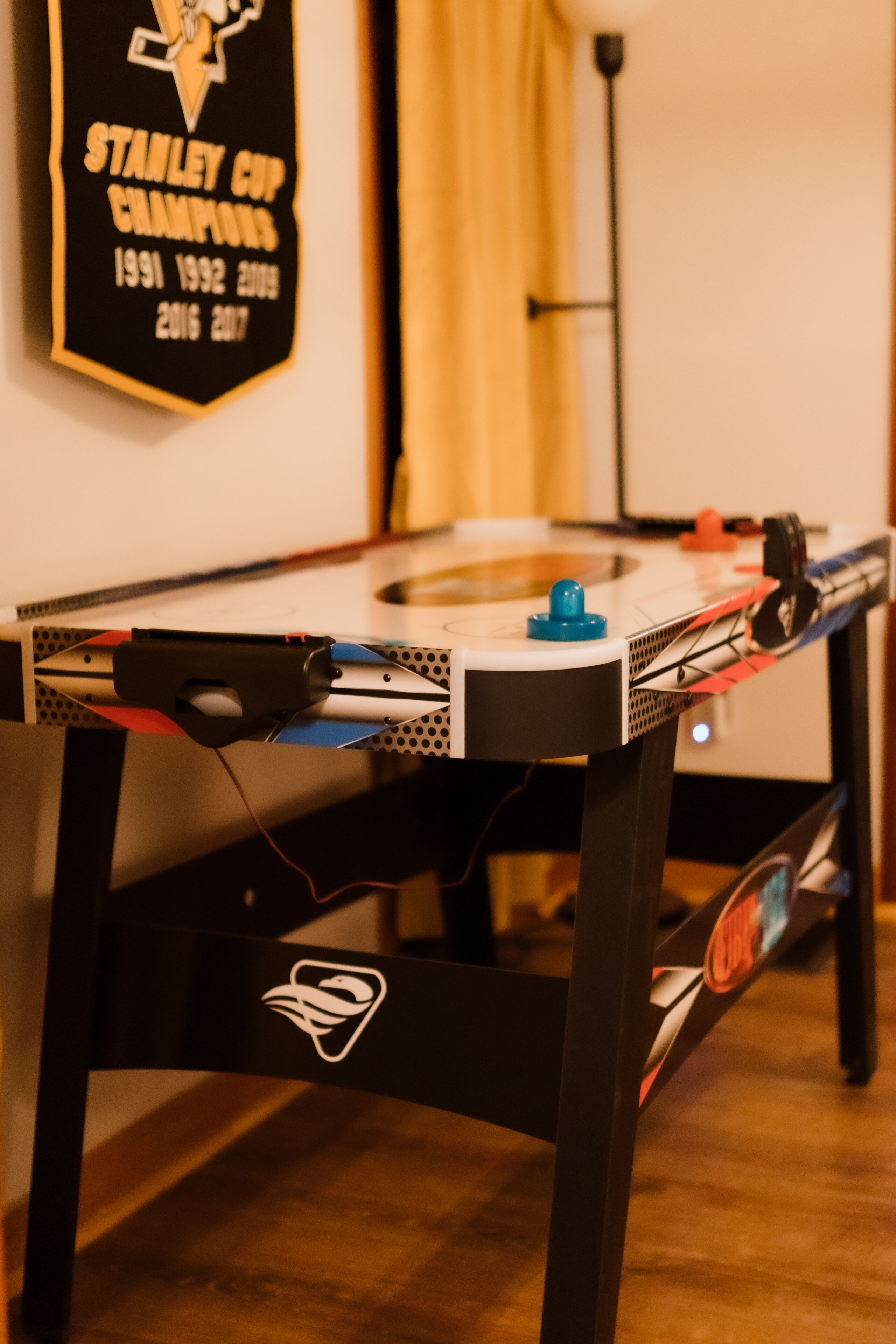 A table with a table tennis table, a trophy, and a lamp.