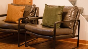 Un fauteuil en cuir, avec une porte en bois et un escalier en arrière-plan.