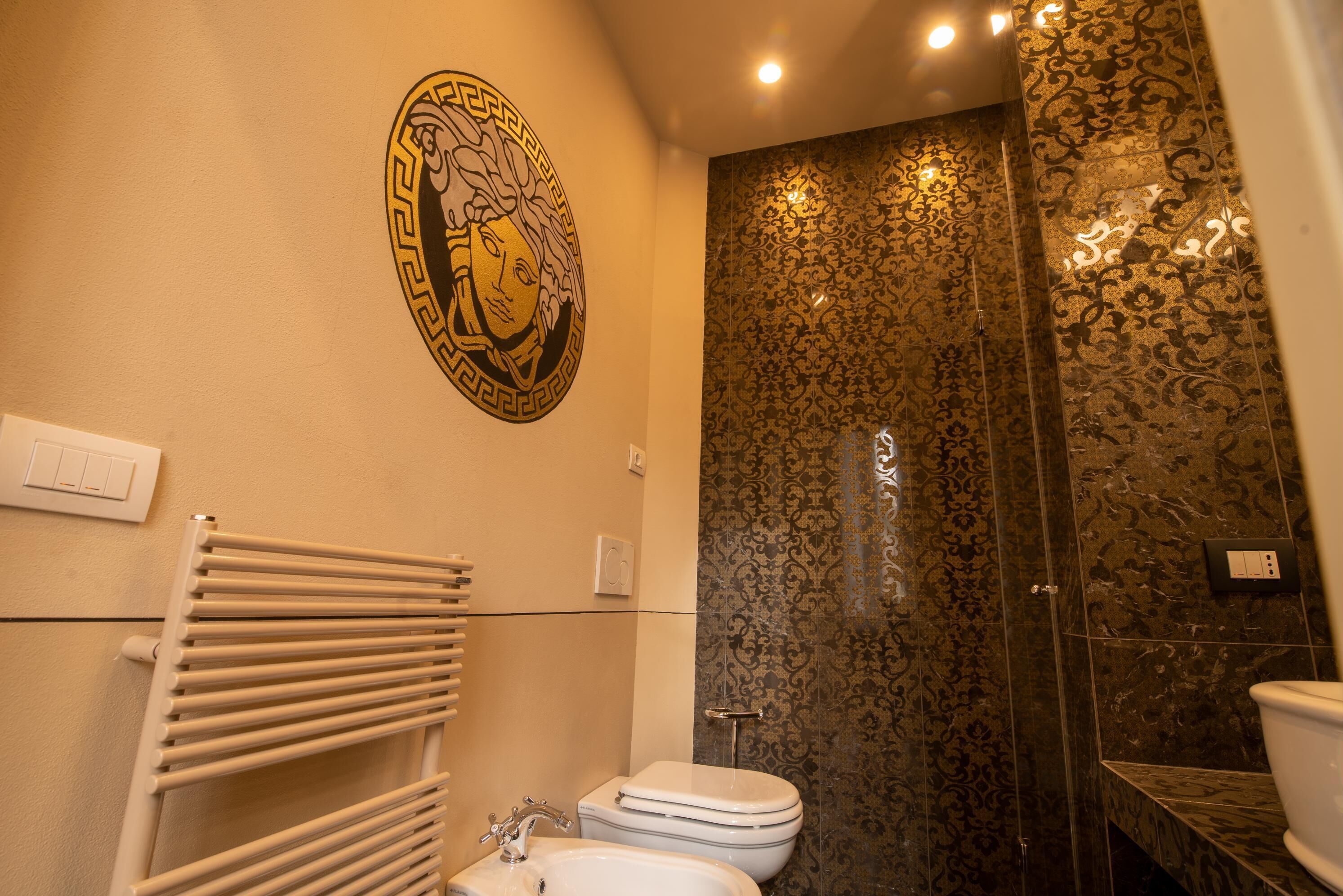 Une salle de bain avec des toilettes blanches, un lavabo et un porte-serviettes.