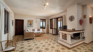 Una sala de estar acogedora con piso estampado, un sofá, una mesa de centro y una chimenea.