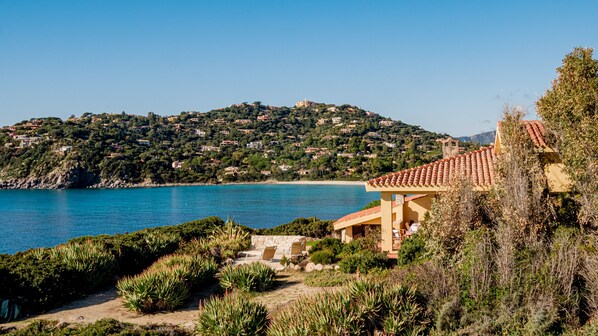 A coastal villa with a view of the sea and a hillside village.