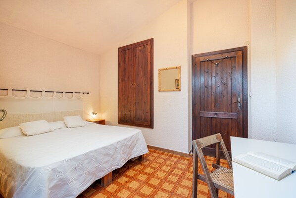 A bedroom with a bed, a chair, a table, and two doors. - New Property - Villa Delle Stelle: unique front sea location - 180 ° sea view (Torre Delle Stelle (Maracalagonis))