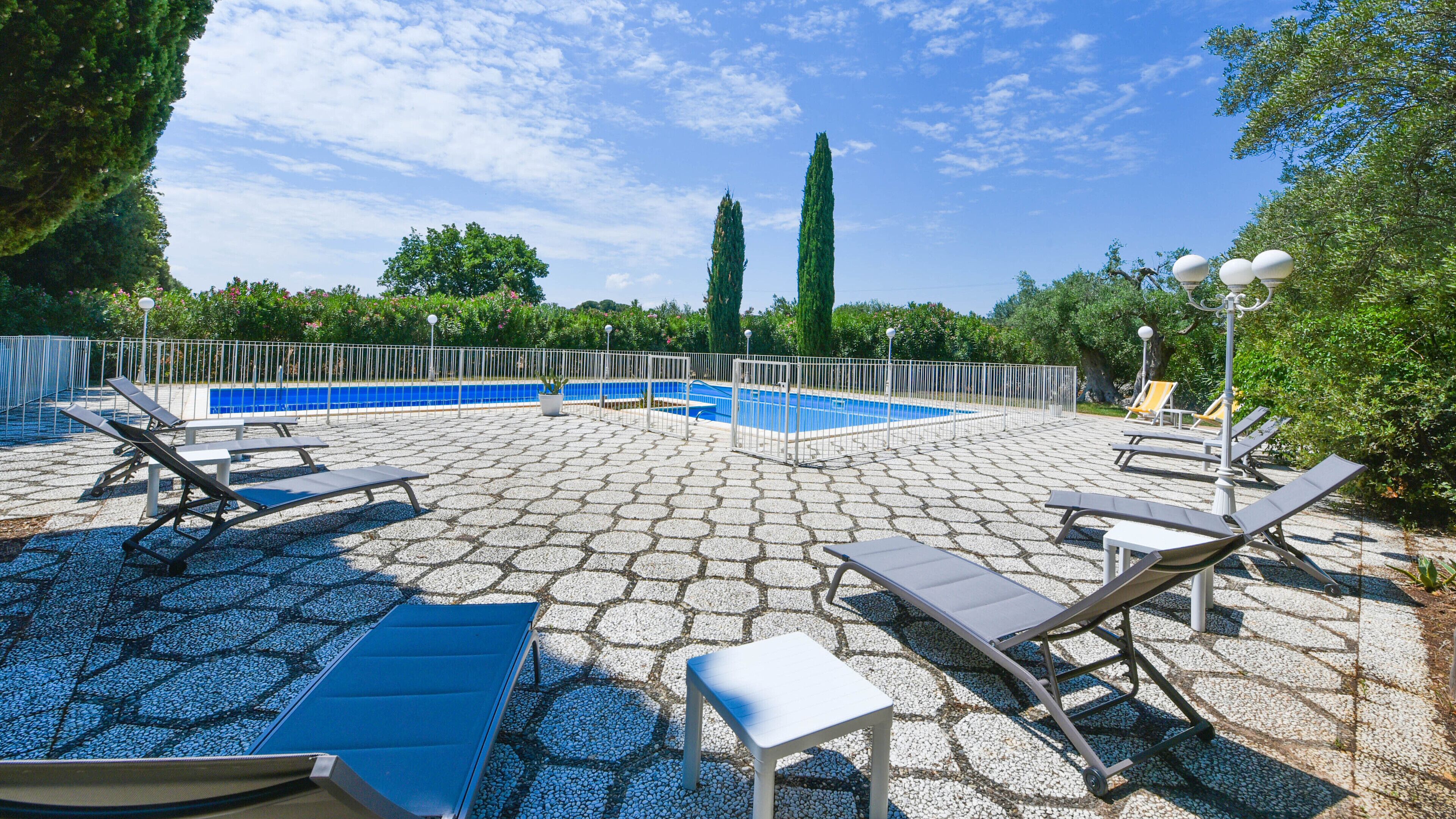 Ein Poolbereich mit Liegestühlen und einem kleinen Pool.