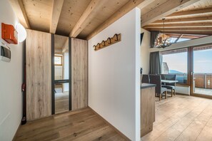 Ein modernes Interieur mit Holzbalken, einem Essbereich mit Aussicht und einem Kleiderständer.