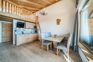 Eine moderne Küche mit Holzausbau, einer integrierten Mikrowelle und einem Essbereich mit Tisch und Stühlen.