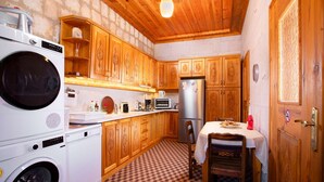 Una cocina compacta con armarios de madera, lavadora, microondas y refrigerador.