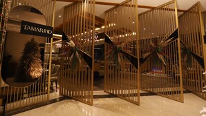 Un intérieur moderne agrémenté d'une enseigne « Tamarind », d'un escalier et de plantes décoratives.