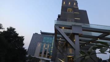 A modern building with the sign 'PRISTINE' at the top. It features a glass facade and a metal structure in the foreground.