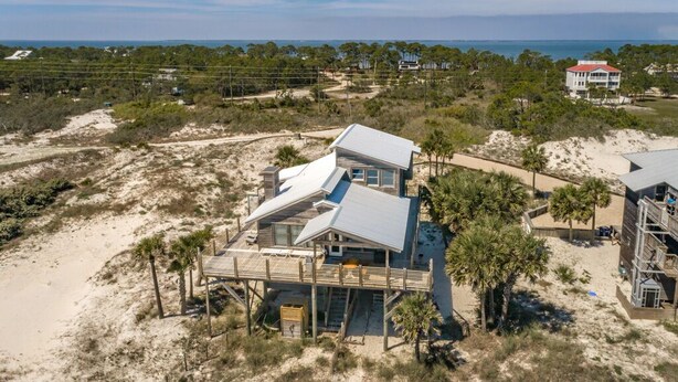 Une maison située en bord de mer, dotée d’une grande terrasse, de plusieurs niveaux et offrant une vue sur l’océan.