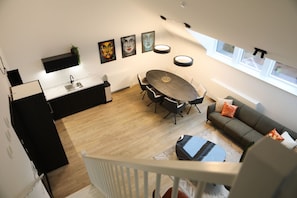 Una cocina moderna con comedor, sofá y escalera.