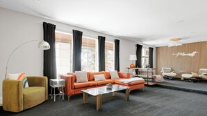 A modern living room with a sectional sofa, a coffee table, a floor lamp, and a side table.
