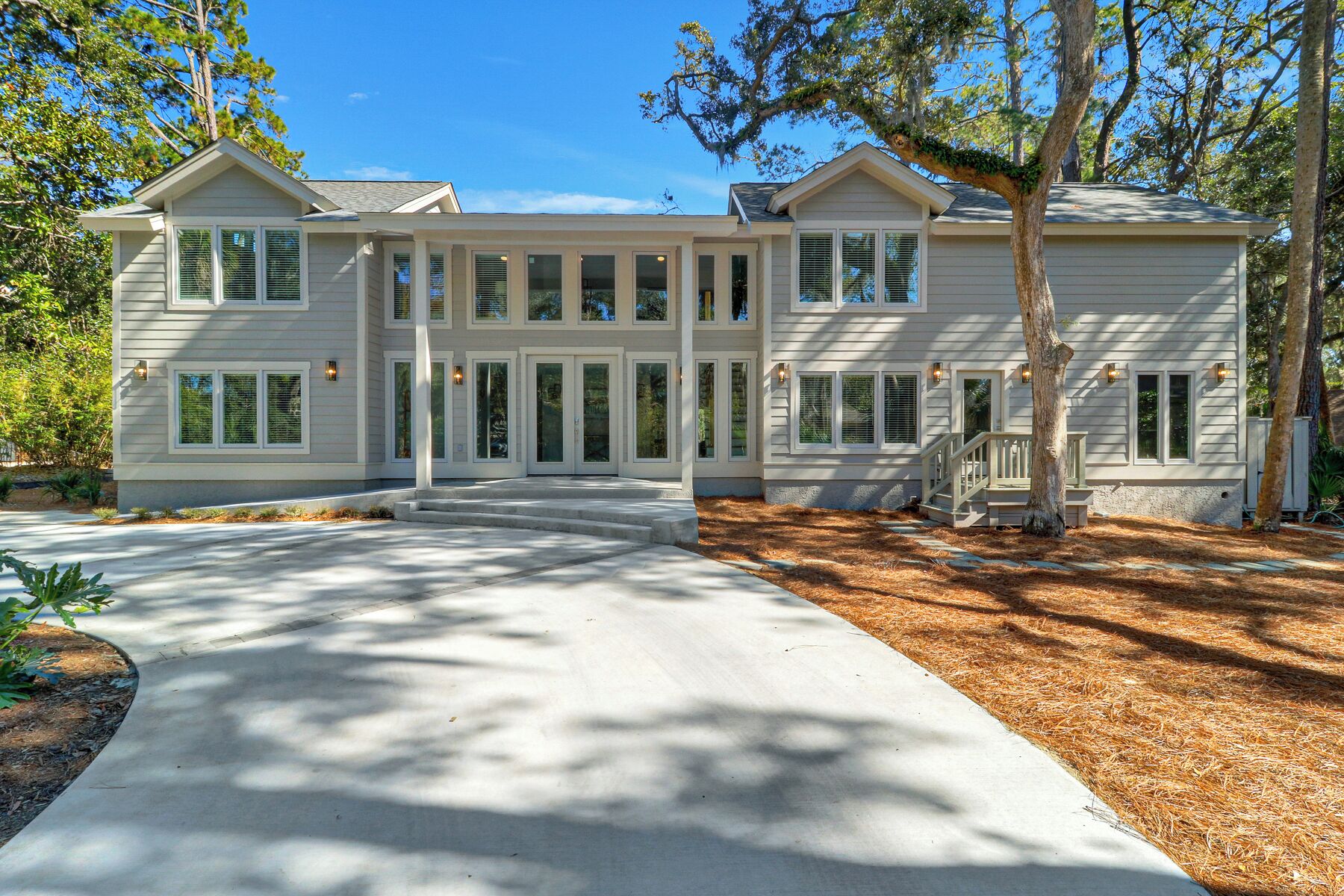 A large, two-story house with a covered front porch, multiple windows, and a well-maintained lawn.