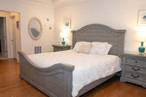 Une chambre à coucher avec un lit, des tables de chevet, un miroir et des éléments de décoration murale.