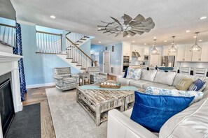 A spacious living room with a staircase, a dining area, and a kitchen. - Bayside * 5BR New Luxury House (Selbyville)