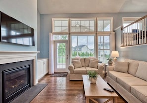 A living room with a fireplace, a sofa, a coffee table, and a television.