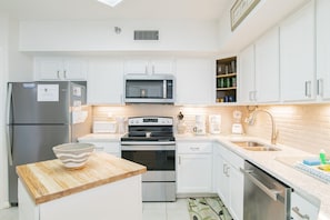 Fully equipped kitchen with refrigerator, microwave, oven, and dishwasher.
