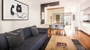 A modern living room with a sofa, a coffee table, and a framed artwork of a telephone.