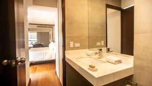 A modern bathroom with a large mirror, a sink, and a toilet.