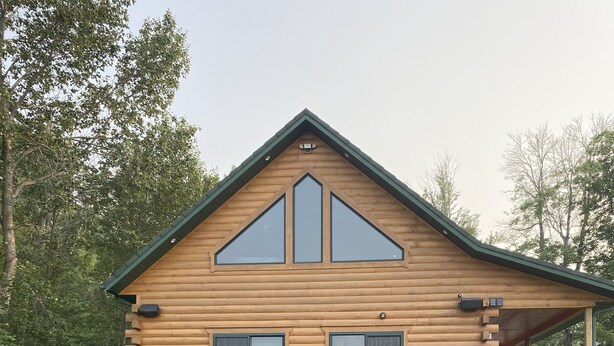 A log cabin with a large deck, a hot tub, and a covered porch. - Luxury Waterfront Log Cabin ... Memories Abound (Crivitz)