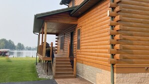 A log cabin with a porch and a view of a lake. - Luxury Waterfront Log Cabin ... Memories Abound (Crivitz)