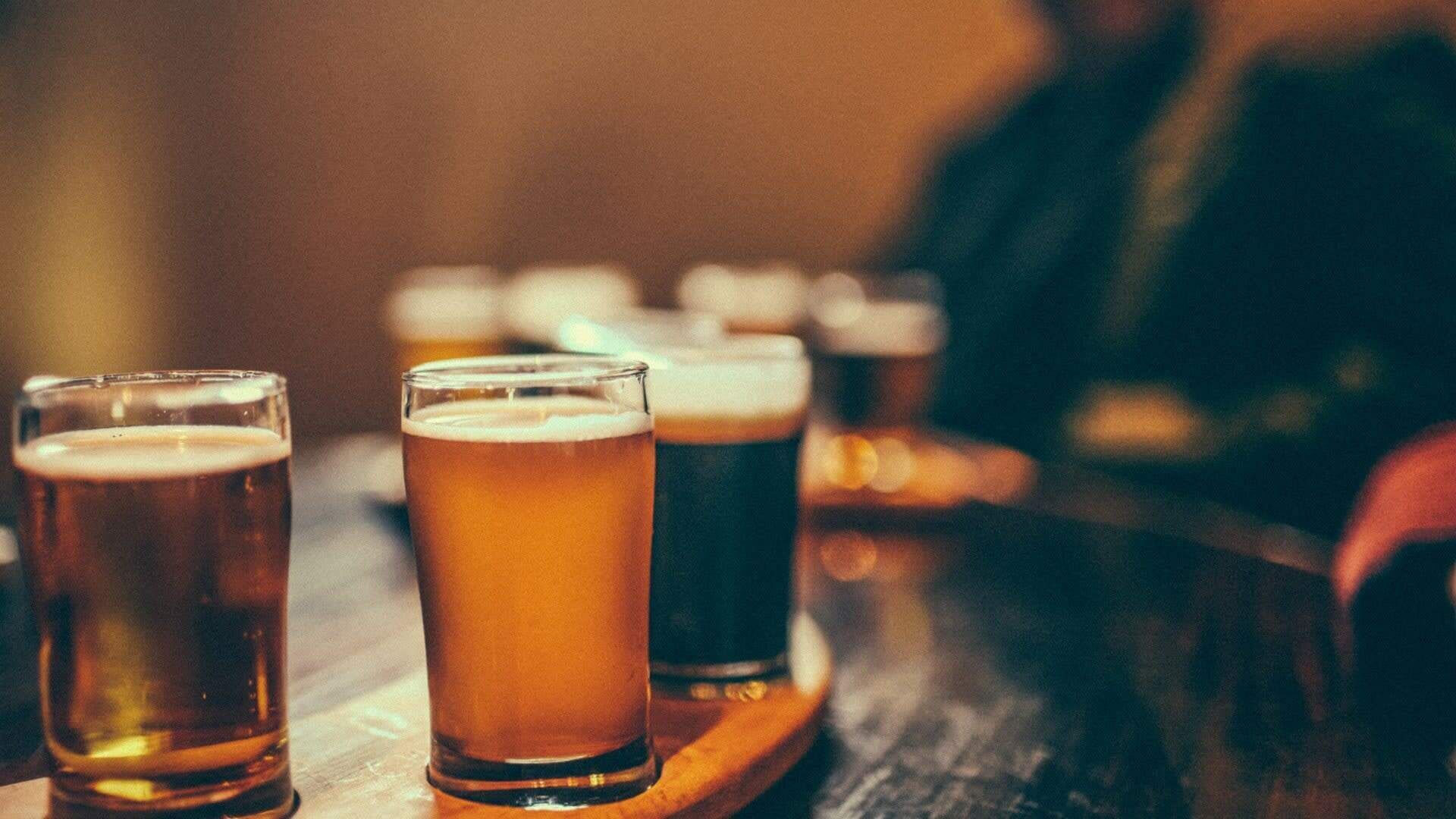 Mehrere Biergläser auf einer Holztasse.