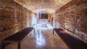 A narrow corridor with brick walls, a metal ladder, and benches. - Country House with heated pool near the center (Firenze)