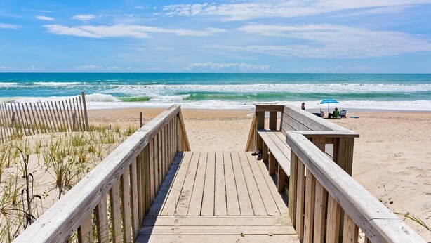 A wooden boardwalk leading to a beach with a clear view of the ocean. - Oceanfront Condo w/Views, Pool + Parking (Surf City)